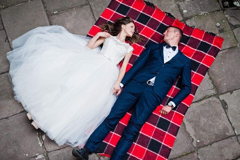 Wedding couple lying on blankets. Photo from quad copter drone view